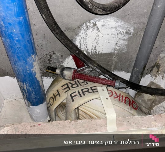 צינור כיבוי אש מגולגל עם כיתוב FIRE HOSE